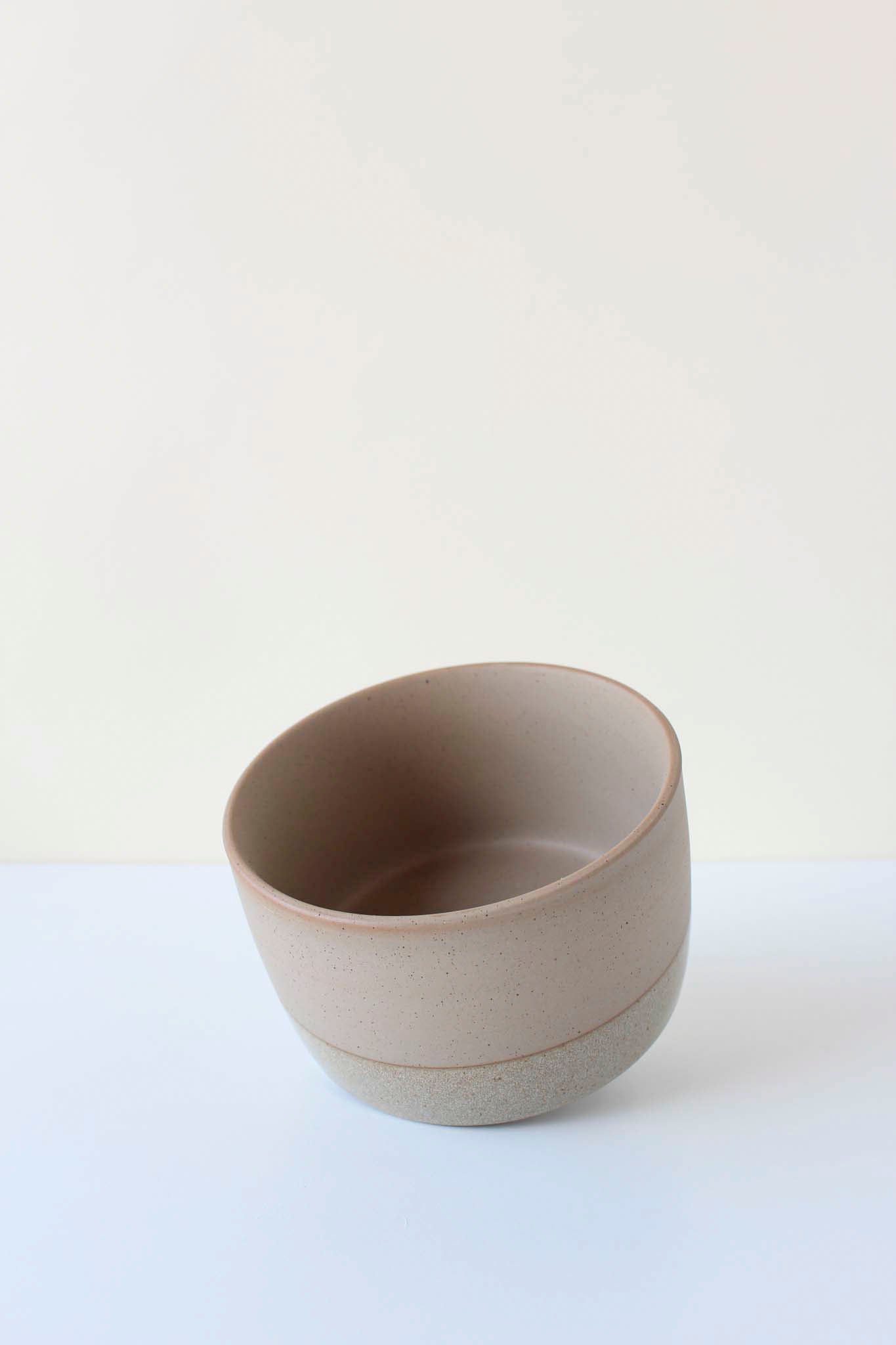 A light beige ceramic soaking dish tipped on its side to see the inside