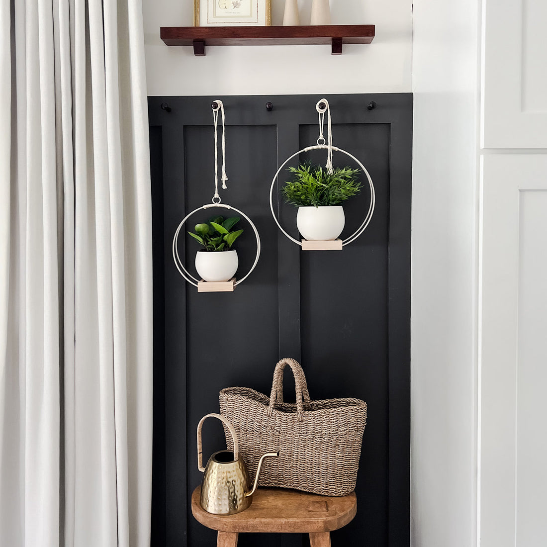 two white modern hanging planters and pots by braid & wood styled above vintage stool with basket