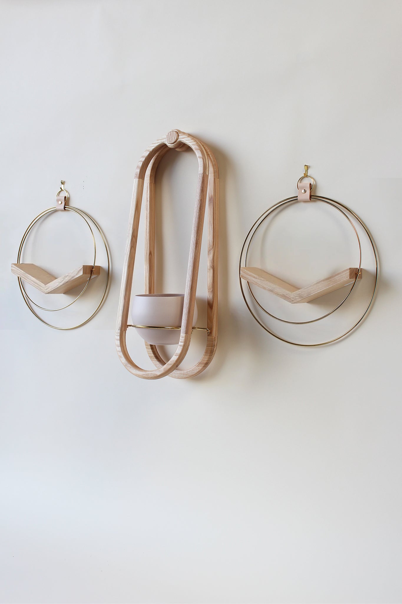 three gold wall mounted plant holders on white background
