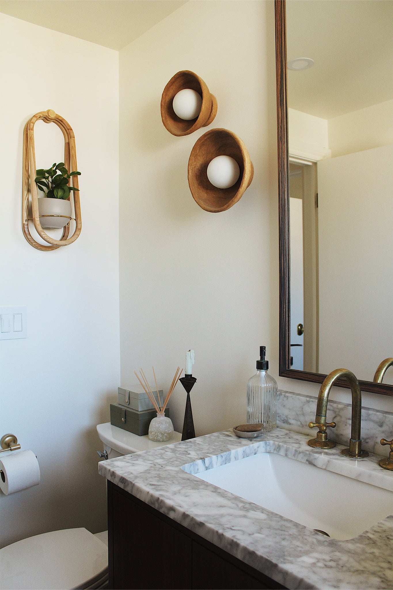 Bathroom interior with marble countertop, sink, and the Frame Wall Planter and spun aluminum pot.
