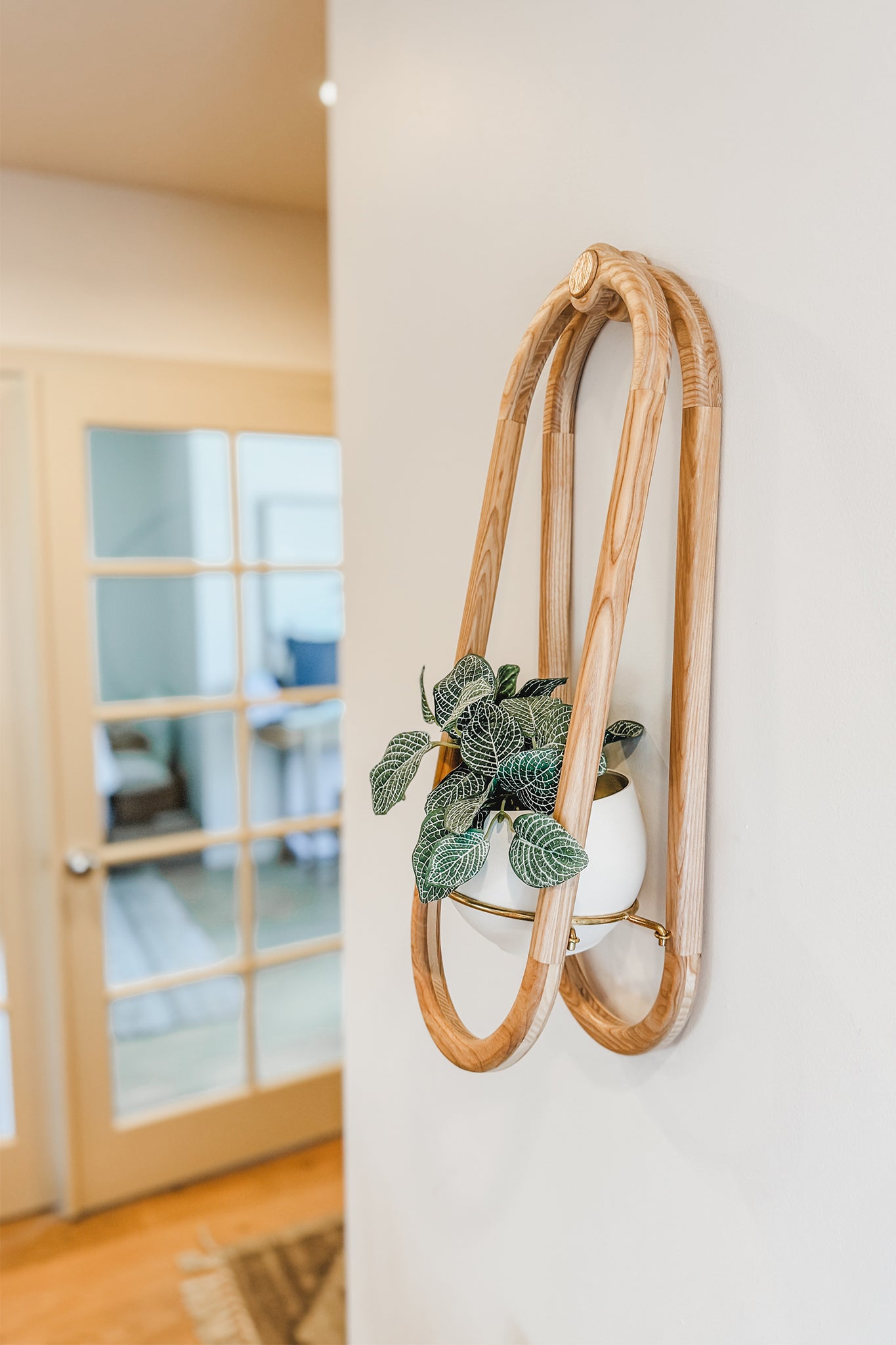 The Frame Wall Planter and spun aluminum pot on a skinny wall in a modern kitchen.
