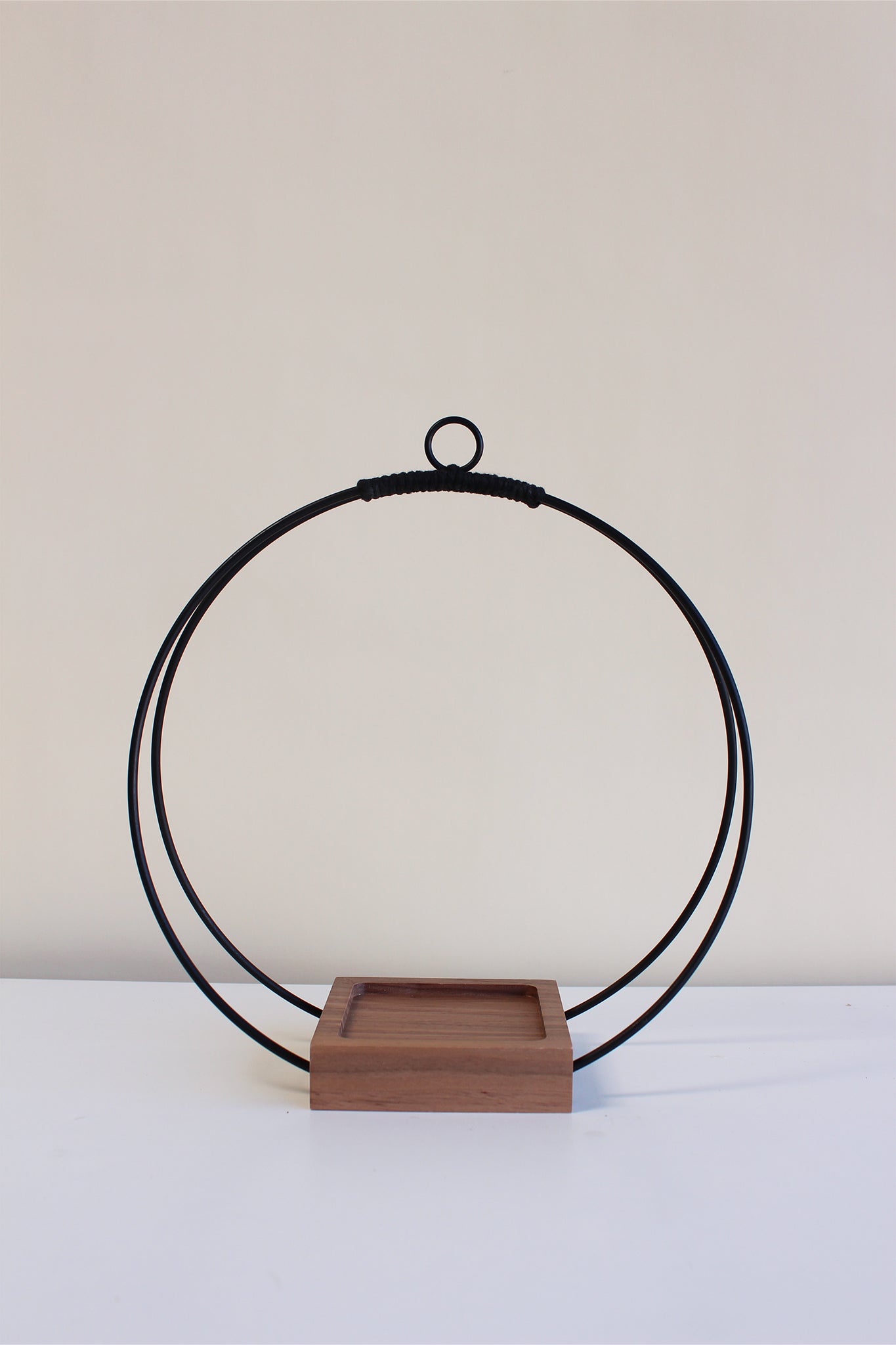 medium circular hanging planter with matte black rings, walnut wood base and no pot