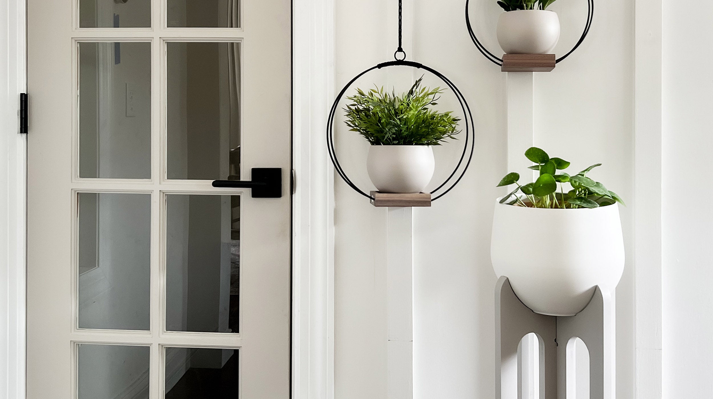 braid & wood hanging planters and plant stand styled next to entry door