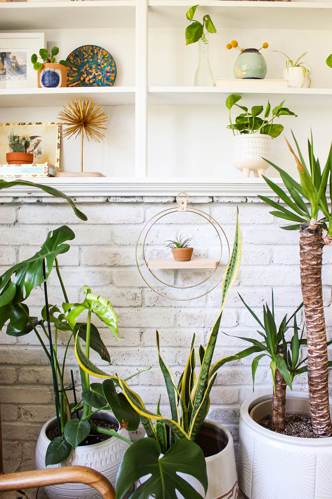 braid and wood plant shelf with terracotta pot hanging on white brick wall