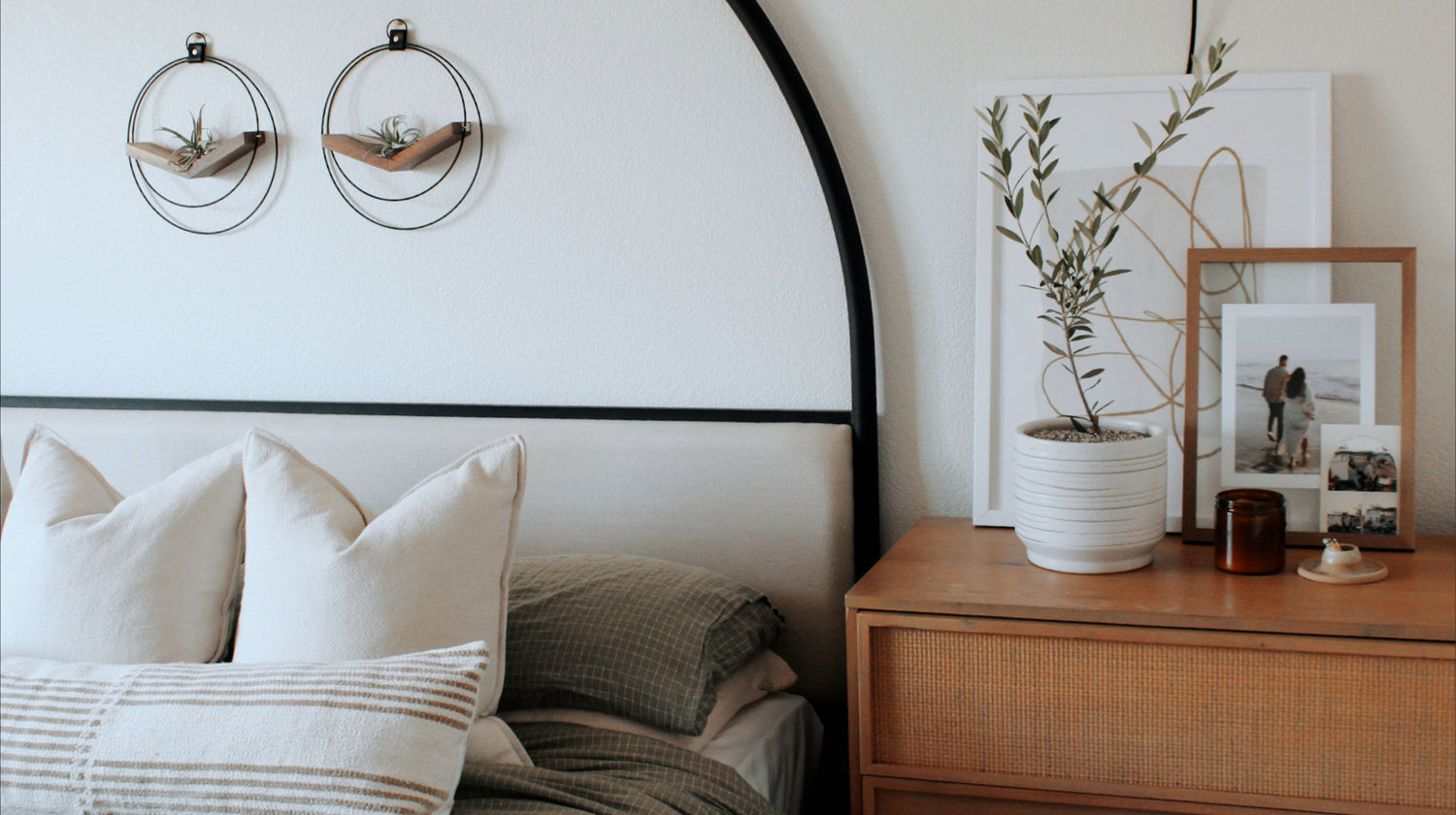 two modern braid & wood v-hangers in black and walnut styled above modern bed