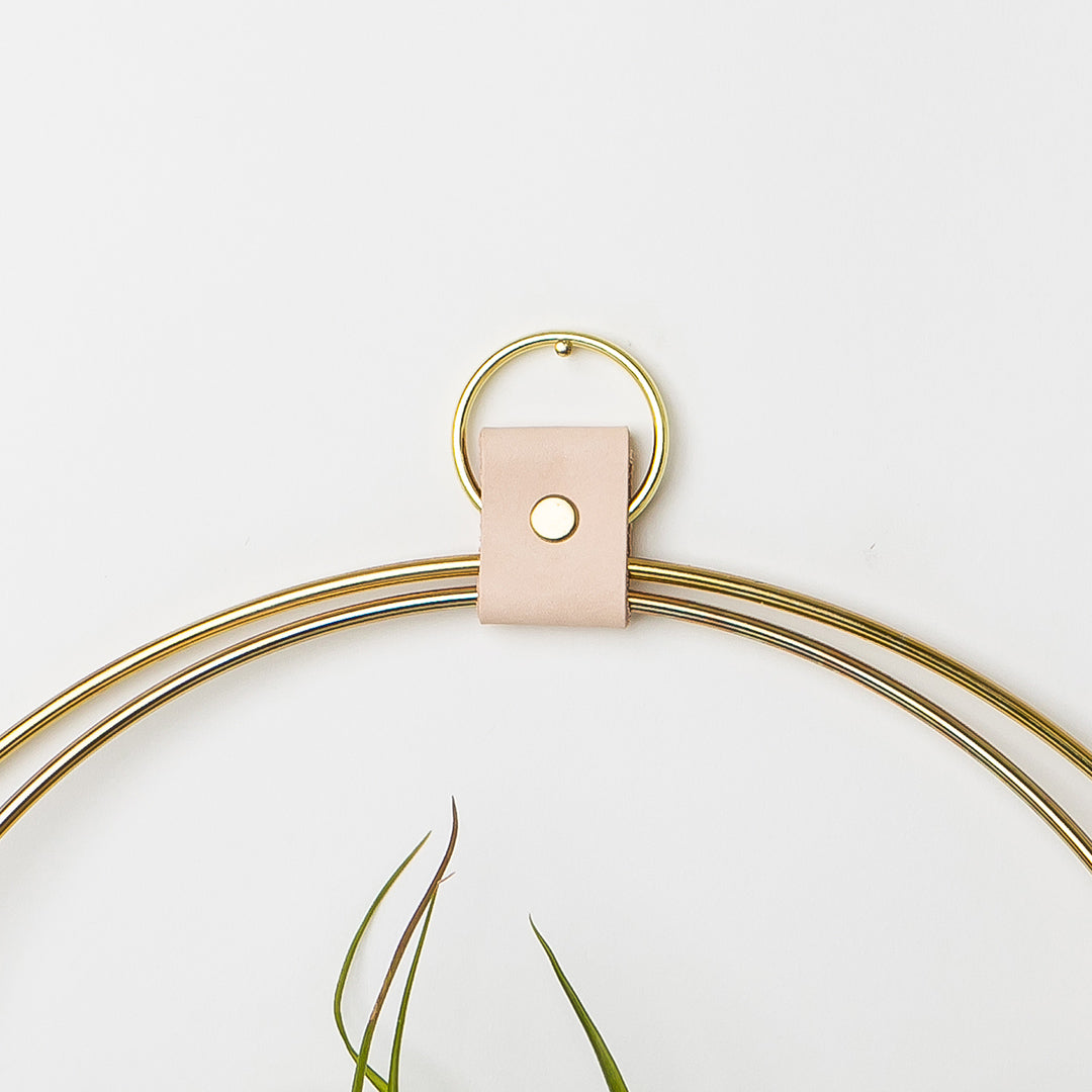 leather strap detail of a large v shaped gold air plant hanger