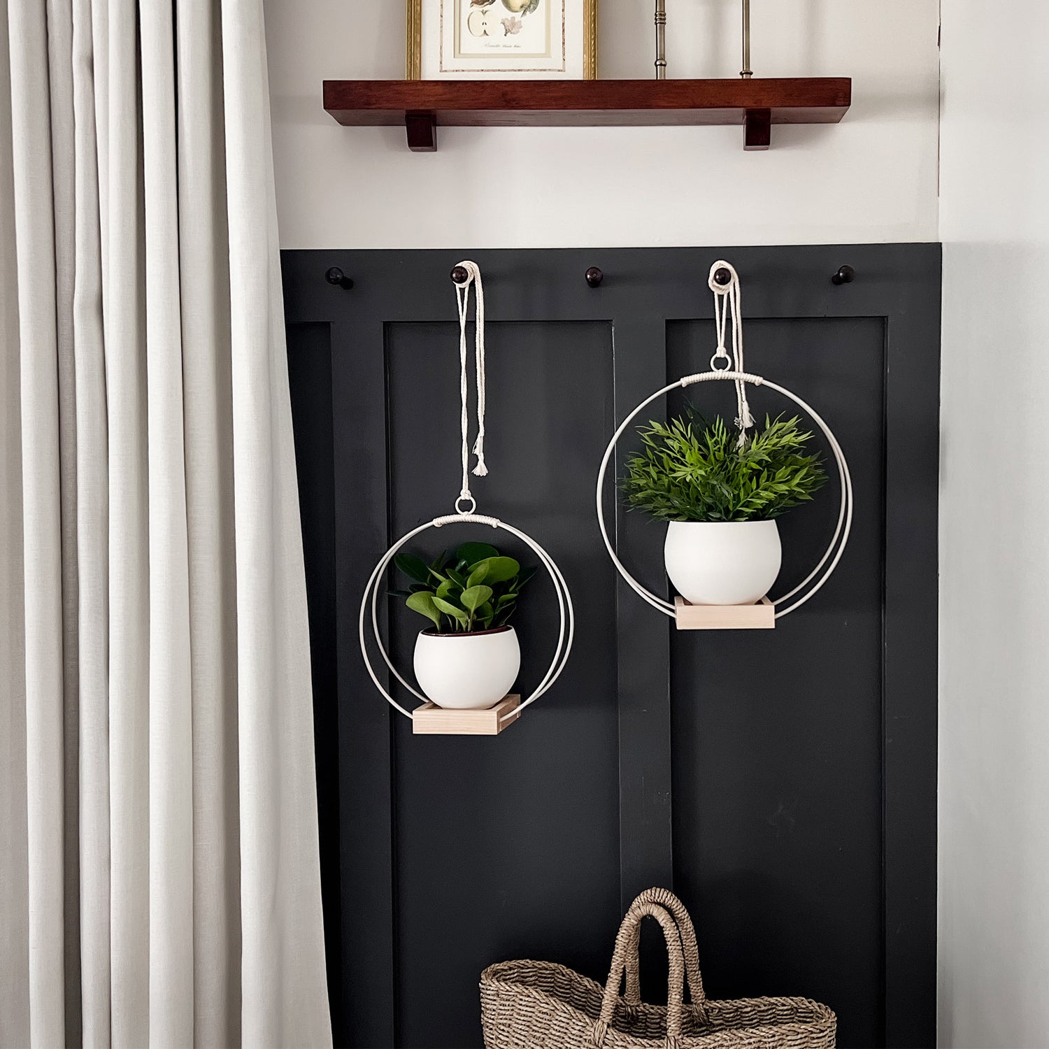 two white metal plant hangers styled in a modern entry way 