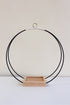 large circular hanging planter with matte black rings and no pot