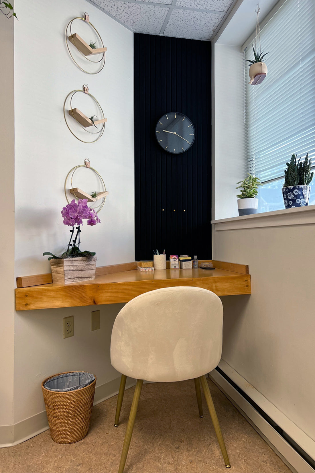 Small home office with wooden desk, chair, and decorative elements.