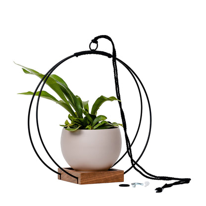 large plant hanger with black metal and walnut wood base and tan colored aluminum pot