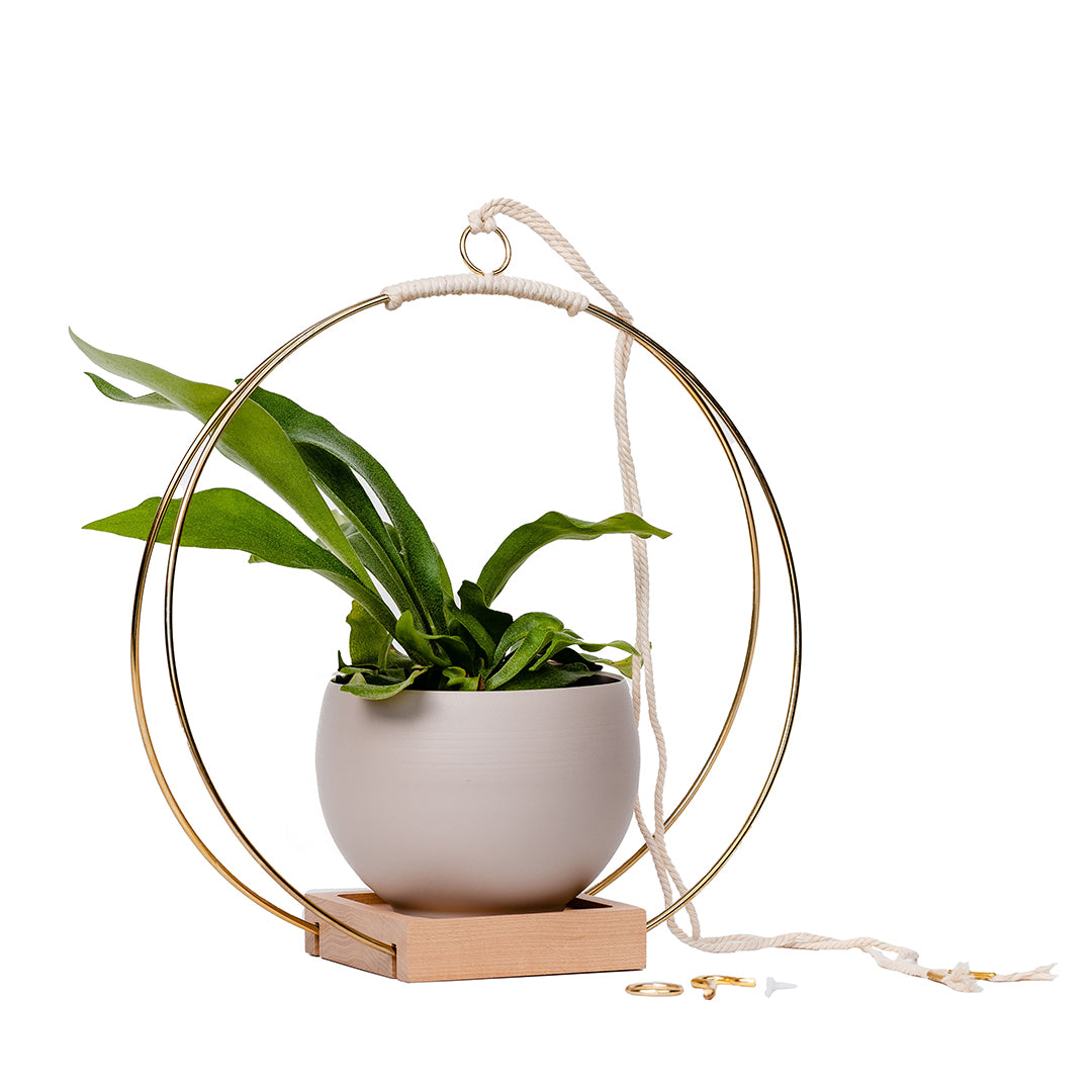 large plant hanger with gold metal and maple wood base and tan colored aluminum pot